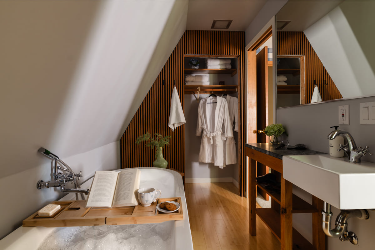 The bath, a tub under the slope and robes on the rail